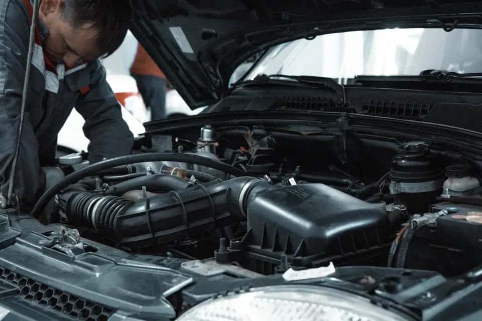 Mechanik sprawdza komorę silnika używanego samochodu